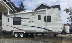 2012 27' tandem axle travel trailer with 10,x40" slide and two doors. The unit has rear kitchen with: propane/electric fridge freezer, micro wave, stove/oven combo, double sink and lots of drawers and cupboards. Fold down couch,closet and fridge located