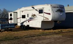 5th Wheel camper for sale with hard wall exterior. There are two single slides and one double slide. Front master bedroom with large closet. Quad bunks located in the back room. Central room has the kitchen with free standing table and pull out sofa. Roof