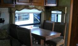 This is a wonderful trailer with a great rear living area with fireplace, computer table/chair, opposing slides to add space, free standing table, sofa, spacious kitchen and great finishes.
The master bedroom is large and has a walk around bed, shower is