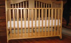 In new condition, Pine crib with clean mattress