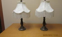 Set of two bedside lamps with brass base, creme shades with fringe, 16' high, takes 40 watt bulb. Good condition.