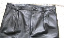 Very soft black leather pants with front slash pockets and pleats. No rear pockets. Two minor scuff spots where leather surface has been scratched away, and finish wear on the cuffs (could probably touch up with shoe polish or felt marker). Lined fully to