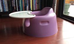 Purple bumbo seat with tray. Safety belt is also installed.