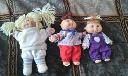 3 cute little Cabbage Patch Dolls. The bigger one is soft bodied, the other two are plastic. Adult owned. Display only. Found an extra little outfit that goes with the bigger doll. About 2-4 inches big.