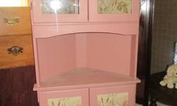 I have a paintable corner cabinet with glass doors on top, and solid doors on bottom, with a display shelf in the middle. The floral decor on the unit is easily removed, as it is just decorative unattached paper.
email amanda at kincsem1015@hotmail.com if