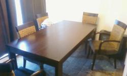 The table is only 3 years old , in good condition . I had paid over 1200 at the time of purchase . There is 4 arm chairs and 2 unarmed chairs . Seats are very comfortable and are covered in a thick leather . Asking $400 or best offer . Moving at the end