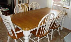 Oak dining set. Table is "British isles" oak with "Buttermilk" legs. 77" long with leaf (18")., 41" wide. Chairs- 2 high back with arms, 4 rounded back, all oak seats with buttermilk legs and back (very mildly distressed). Very good condition. Purchased