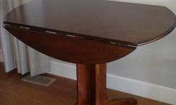 Drop-Leaf Table, solid wood. Opens to a 40" round. Pedestal base. Excellent condition; was $300 new, will sell for $75. Good for a small space in kitchen or dining area.