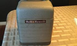 Bell and Howell film projector with Sears screen. Watch your beloved home movies on this vintage machine.