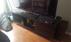 Good condition black tv stand with glass on both sides. One piece of glass is missing the metal piece for the magnet. Couple small marks on it. Pick up only.