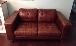 Leather loveseat in caramel brown colour purchased from Muse and Merchant for $1000 1.5 years ago. No tears and rips and in good condition. It is 61 inches wide, 37 inches depth and 30 inches tall. Please email for more questions or to view. Can be viewed