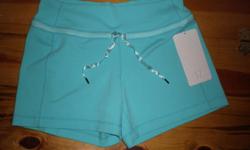 Adorable pair of Lululemon Luon Knock Out Shorts in a pretty aqua color. The Lululemon logo is positioned on the left lower pant leg. The drawstring is of a shiny satin with Lululemon logo and written text that says "Join the sweat revolution". NEW WITH