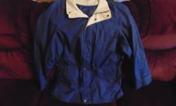 Men's lined jacket. Zip front, with snaps and Velcro too. Waist drawstring to keep the cool air out. Rollaway hood. 2 front Velcro pockets and one Velcro breast pocket inside. Adjustable cuff size. Navy with beige collar. Machine washable. Size XL