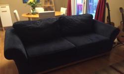 Navy blue couch with wooden base and legs. Has survived through a dog and two kids but otherwise is good condition. Upper pillows are attached.
