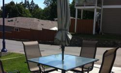 Wrought-iron, glass patio table with 4 chairs (swivel rockers) includes umbrella