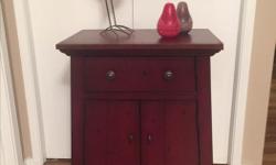 This distressed red accent table would make a great bedside table, hall table, or a great accent anywhere in your home. In excellent condition; drawer and cabinet doors functional. It is 19.5" long, 13" wide and 26" tall. Price firm - cannot deliver.