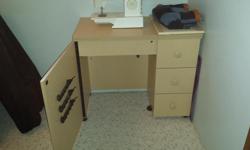 Sewing Cabinet/Desk with fold out top to increase work space, hardware to attach sewing machine to drop down shelf. Thread and bobbin storage on inside of door. 3 easy-pull drawers. Excellent condition.