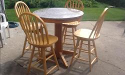 Solid wood pedestal pub able with granite top and four chairs. Table top is 36" in diameter and stands 36 1/2" tall. All chairs will swivel if desired.