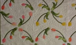 Hand applique 100% Cotton
44 x 58"
Offered at a steal of a deal in time for gift giving along with many other quilts.  This quilt is a good size for napping under and dreaming of what will pop up in the spring.  Pastel coloured tulips are hand appliqued
