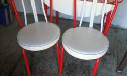 Table had 2 drop ends with red accents. 4 chairs are white vinyl with no tears and red accents.Set is in good condition.