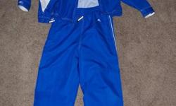 Blue with white trim (South Calgary Ringette) child's coat and pants tracksuit made by Stormtech. Zipper pockets, Velcro cuffs, string tie waistband, size youth medium (approx age 8-11).