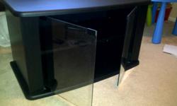 Black TV Stand in New condition. Perfect for 42" or larger TV's 
 
Adjustable shelving behind glass doors.
 
Dimensions:  36" Length x 20" Depth x 20" Height
 
Consider delivery pending location of buyer
