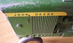 This is a lot of (3) three John Deere diecast toys from the early 1960's. All pieces are completely original and in very good condition. The tractor (length 9", width 5", height 5") is missing the rubber exhaust stack and the disc is missing one of the