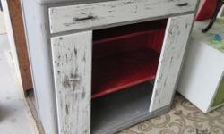 Colorful vintage wood cabinet with that farmhouse feel. Large upper drawer and open front lower cabinet with 2 fixed shelves - top one is a half shelf. Grey, white, and red and distressed. Measures 42" wide, 17" deep, and 44" tall. I live in Gordon Head.