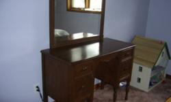 We are selling a wooden vanity table with mirror. Size: 18" deep X 39" wide X 56 1/2" high. It has 4 drawers. It's in good condition, but it does has some marks on it. Comes with a stool. (material on steel frame, not wooden) Chesley.