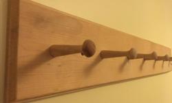 Nice wooden wall rack for hanging your coats, bags, hats, etc. It mounts on with two screws. Pegs are approximately 7cm long and about 10cm apart, the rack is approximately 80x15 cm.